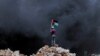 Palestine - Palestinian protester waves Palestine flag during clashes over the Jewish settlement of Qadomem at Kofr Qadom village, near West Bank city of Nablus, 13 June 2014