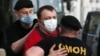 BELARUS -- MINSK, JUNE 23, 2020: Servicemen of Belarus' Special Purpose Police Unit (OMON) detain a man by the Symbal.by shop selling gifts and souvenirs with Belarusian national symbols. After the shop announced its closure on June 29, a line gathered ou